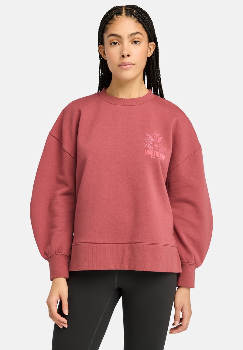 Maroon huppari, jossa on löysä malli, ribatut hihansuut ja helma. Vasemmassa rinnassa on kukkakuviollinen Timberland-logo. Pehmeä kangastuntuma.
