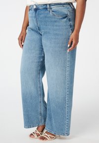 Lichtblauwe wijde jeans met een hoge taille, gemaakt van denimstof, met voorzakken en zichtbare stikseldetails.