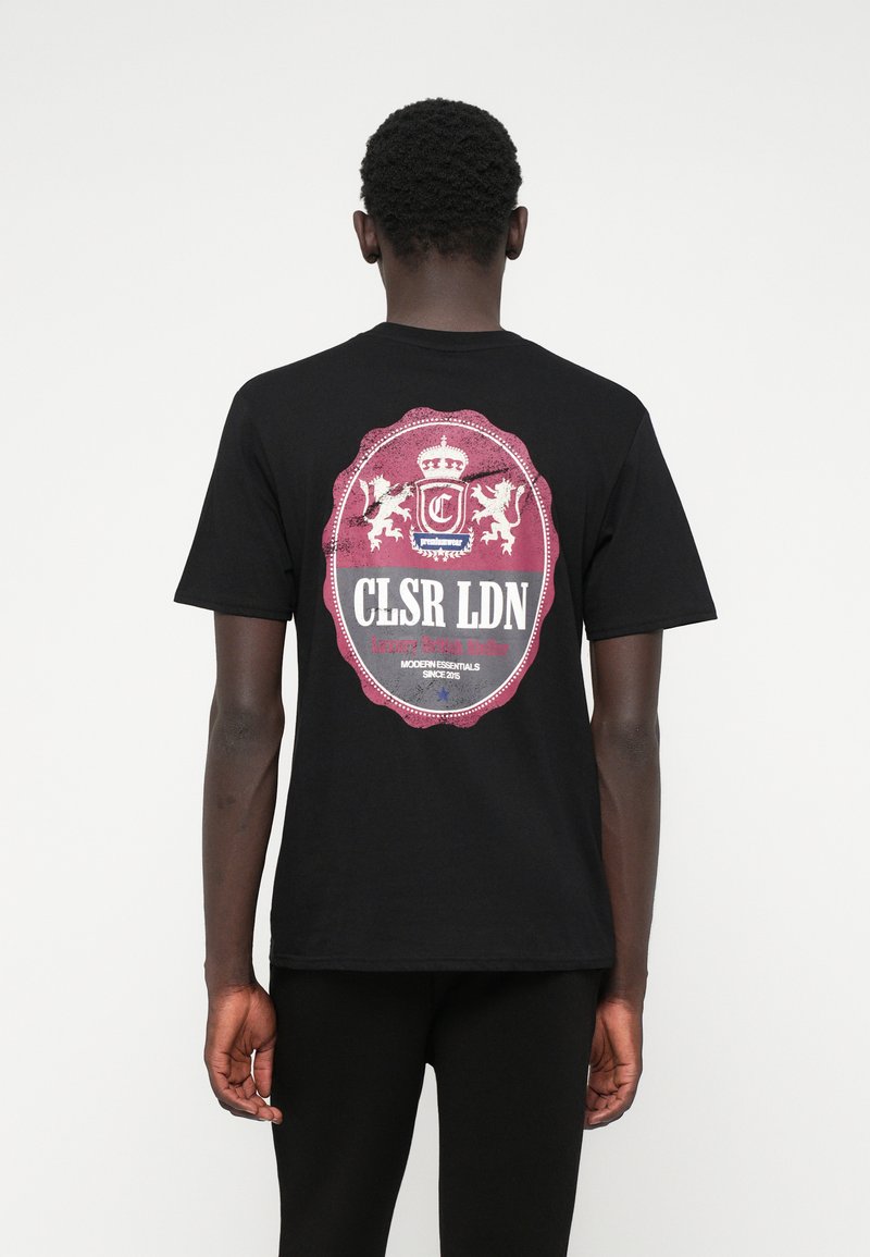 Fekete pamut póló, kerek grafikai nyomattal a hátsó részen, bordó és fehér címer design-nal, rajta a "CLSR LDN" felirattal.