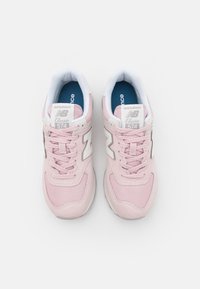 Rosa New Balance 574 Sneakers aus Mesh- und Wildledermaterialien, mit Schnürdesign, weißen Akzenten und gepolsterten Einlegesohlen.