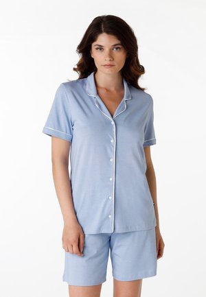 Set di pigiama corto azzurro con maniche corte, composto da una camicia con bottoni e pantaloni corti coordinati. Presenta piping bianco lungo il colletto e le maniche. Texture liscia.
