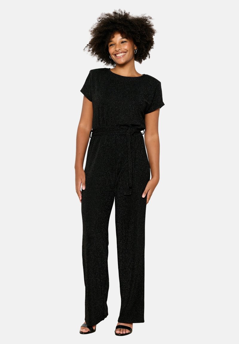 Tuta nera scintillante con maniche corte, vita cinchata e gambe larghe, caratterizzata da una texture liscia e un dettaglio della cintura.