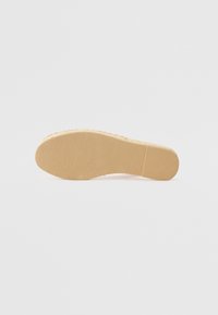 Kengän pohja, jossa on teksturoitu vaaleanbeige kumipinta, uritettu muotoilu, tasainen muoto ja ei näkyviä logoja tai koristeita.