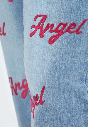 Jeans in denim azzurro chiaro con testo ricamato rosso che scrive "Angel" in un carattere corsivo, con una texture morbida e una vestibilità classica.