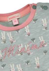 Hellblaues Stoff-Overall mit wiederholtem Kaninchenmuster, pink gesticktem Text "Minime" und kontrastierenden pinken Besätzen mit Druckknöpfen.