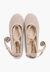Ballet flats beige realizzati in morbido suede, con design a fascia elastica e nastri arrotolati per una vestibilità sicura. Logo ben visibile all'interno.
