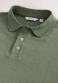 Maslinasto zelena polo majica od teksturiranog pamuka, s ovratnikom, pladnjem s tri gumba i oznakom brenda "NEXT".