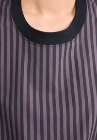 Lätt topp med vertikala mörkgrå och svarta ränder, rund svart halsringning och slät textur. Lämplig för avslappnad användning.