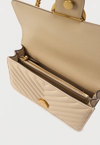 Μπεζ καπιτονέ τσάντα χειρός με χρυσά μεταλλικά στοιχεία, με κούμπωμα κουμπιού και εσωτερική τσέπη με φερμουάρ για καλύτερη οργάνωση. Ομαλό συνθετικό υλικό.