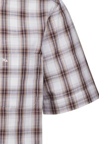 Camicia a maniche corte a quadri in bianco, marrone e blu. Presenta un tessuto leggero, con un dettaglio a tasca e strisce a contrasto.