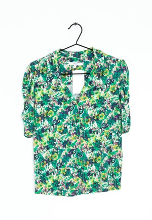 Blusa floreale a maniche corte con un motivo verde, giallo e viola. Presenta un colletto e bottoni sulla parte anteriore. Tessuto leggero.
