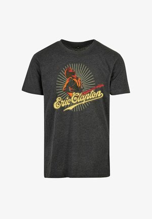 Grå bomulds t-shirt med et grafik af en musiker med en guitar, omgivet af et strålende design, og navnet "Eric Clapton" i gult.