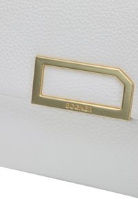 Hvid lædertaske med strukturér overflade, gulddetaljer i rektangulær form og indgraveret "BOGNER" logo.