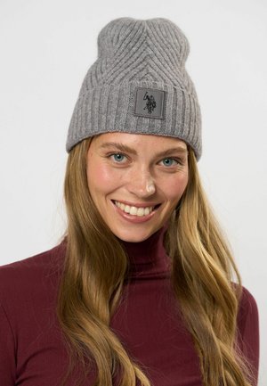 Harmaa neulottu pipo, jossa on ribbikuvio ja musta logo-ompelus edessä. Lämmin, joustava materiaali ja pyöreä muotoilu.