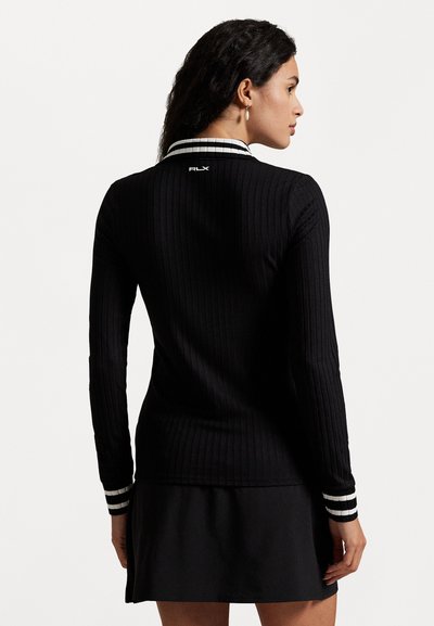 Black ribbed long-sleeve shirt with a white striped collar and cuffs. Features subtle branding on the back, and a fitted, smooth texture.