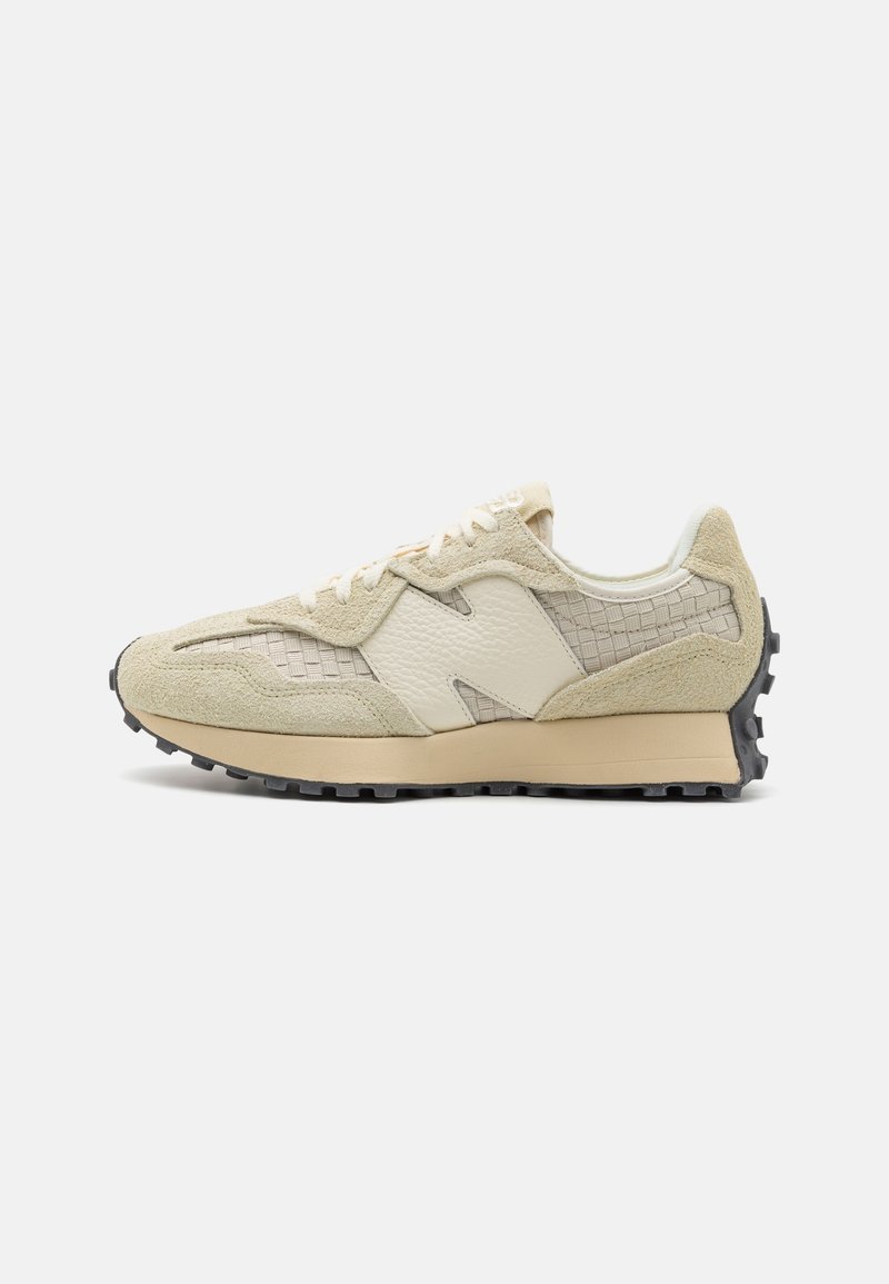 Beige- und cremefarbene Sneaker aus strukturiertem Leder, mit Wildlederüberzügen, gewebtem Seitenpanel, Schnürverschluss und gemusterter schwarzer Gummisohle vor weißem Hintergrund.