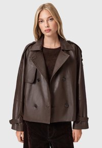 Bruine leren double-breasted jas met een brede kraag, lange mouwen en knoopdetails. Glad oppervlak en een ontspannen pasvorm.