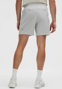 Lichtgrijze sportshorts met een textuurafwerking, elastische tailleband en een klein logootje aan de onderkant aan de linkerkant.