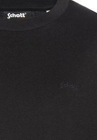 T-shirt nera a costine in cotone con scollatura rotonda. Presenta un piccolo e discreto logo Schott ricamato in colore abbinato sul petto.