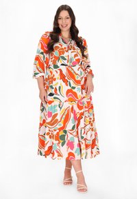 Buntes Blumenkleid im Maxiformat mit lebhaften Mustern in Orange, Pink und Grün, runder Halslinie und drei Viertelärmeln.
