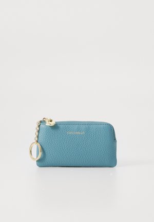 Teal textured leather zip pouch with gold zipper, small gold chain, and circular keyring attached on a white background.