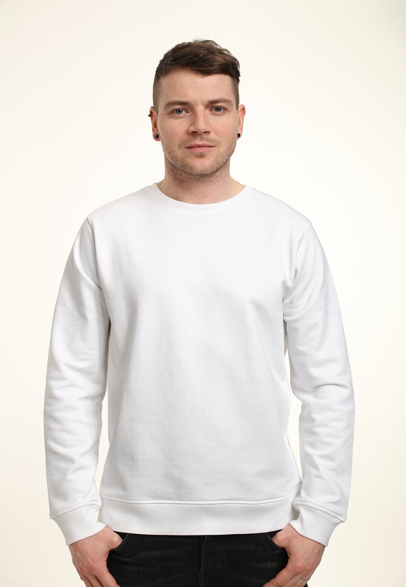 Bílý sweatshirt s kulatým výstřihem a dlouhými rukávy, vyrobený z jemného materiálu. Žebrované manžety a pas, minimální design bez vzorů nebo akcentů.