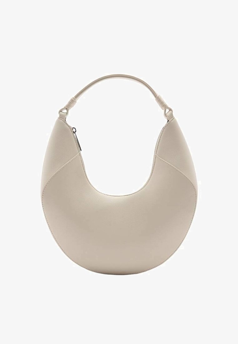 Sac à main en cuir beige en forme de croissant avec une courte poignée et une fermeture éclair sur un côté, présenté sur un fond blanc.