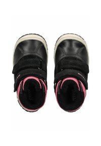 Zapatos infantiles de cuero y ante negro con interior rosa, que cuentan con dos correas de velcro y una suela de goma blanca.