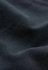 Material denim de culoare închisă, cu o suprafață netedă și texturată. Acesta are o nuanță bogată de albastru închis și modele diagonale subtile de țesătură.