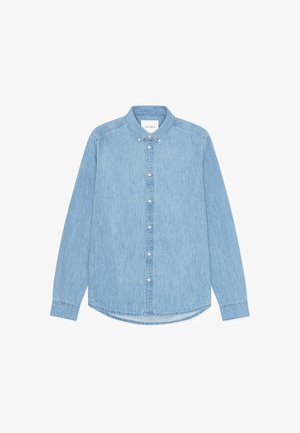 Jasnoniebieska koszula denimowa na guziki z długimi rękawami, spiczastym kołnierzem i zaokrąglonym dołem. Posiada zapięcie na guziki z przodu oraz mały detal z logo.