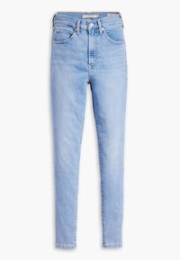 Jeans de tiro alto en azul claro, hechos de denim. Cuentan con cinco bolsillos, cremallera en la bragueta y una silueta ajustada con pierna ceñida.
