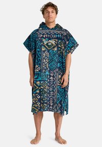 Blå og aqua mønstret poncho lavet af frotté med hætte. Har geometriske design og et logo på brystet. Letvægts og afslappet pasform.