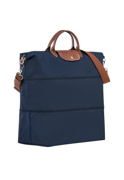 Navy blue nylon tote bag with brown leather accents, two top handles, a detachable shoulder strap, and zippered compartments.