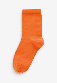 Lys orange bomuldsstrømpe med en glat tekstur, der har en længde til anklerne, ribbet manchet og en afrundet tå. Ingen mønstre eller accenter.