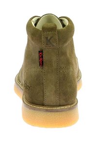 Bottines en daim vertes avec un bout rond, semelle en caoutchouc et un petit patch logo à l'arrière. Elles présentent un col rembourré et des détails de couture.