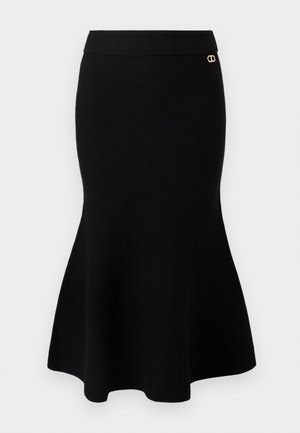 Black knit mermaid skirt with a fitted waist and flared hem. Gold accent detail at the waistband. Smooth texture and seamless design.