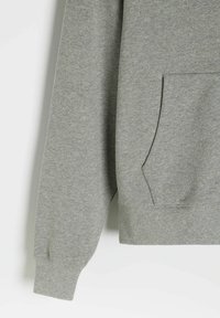 Szary sweatshirt z długimi rękawami, przednią kieszenią, ściągaczami na rękawach i u dołu. Wykonany z miękkiego materiału o gładkiej fakturze.