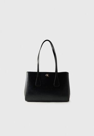 Sort lædernet med to lange håndtag og lille guld "cK" logo foran i midten.