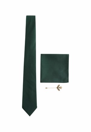 Dark green tie with a subtle ribbed texture, matching pocket square, and a gold lapel pin shaped like a leaf.