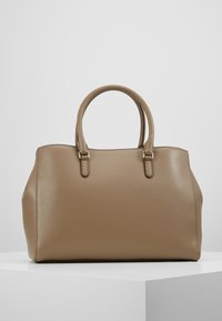Sac à main en cuir beige avec une forme structurée, deux poignées supérieures, une surface texturée et des détails de couture. Pas de quincaillerie visible.