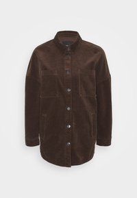 Chaqueta de pana marrón con cuello tipo solapa, cierre frontal de botones y dos bolsillos en el pecho. Presenta una tela texturizada de acanalados y mangas largas.