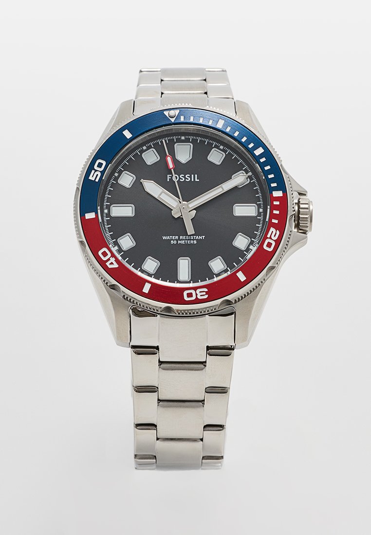 Reloj Fossil con correa de acero inoxidable, esfera negra, acentos plateados y un bisel giratorio en azul y rojo. Resistente al agua hasta 50 metros.