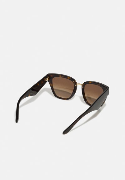 Ochelari de soare cu model țestoasă, cu lentile maro, rame unghiulare și accente din metal aurit. Bratele sunt elegante și ușor înguste.