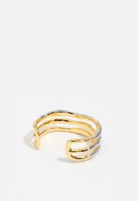 Brazalete de muñeca de oro y plata con un diseño ondulado e entrelazado; presenta superficies metálicas suaves y una forma abierta.