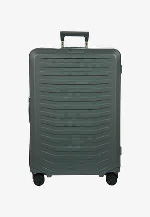 Valigia rigida grande di colore grigio scuro con linee orizzontali testurizzate, quattro ruote e un manico telescopico nero esteso.