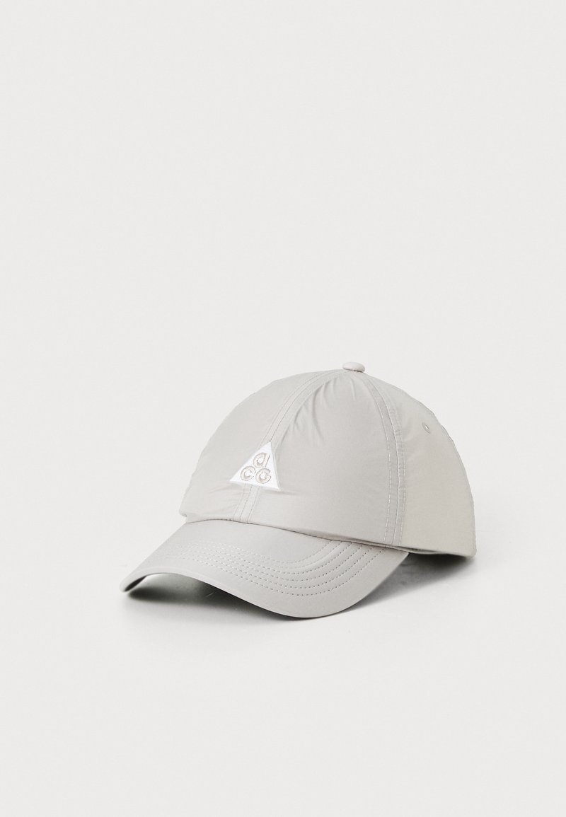 Light gray cap made of soft fabric, featuring a structured bill and a triangular logo patch on the front. Stitch detailing visible.