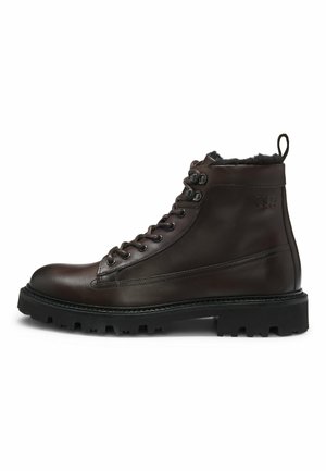 Brown leather ankle boots with laces, round toe, rubber sole, and a textured finish. Features a looped pull tab at the rear.