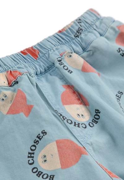 Pantalones cortos azul claro de algodón con un patrón repetido de caras de dibujos animados y el texto "BOBO CHOSES" en negro. Cintura elástica.