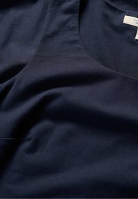 Navyblauw mouwloos topje van zachte katoen, met een ronde halslijn en een zachte textuur, voorzien van subtiele draping en een minimalistisch ontwerp.