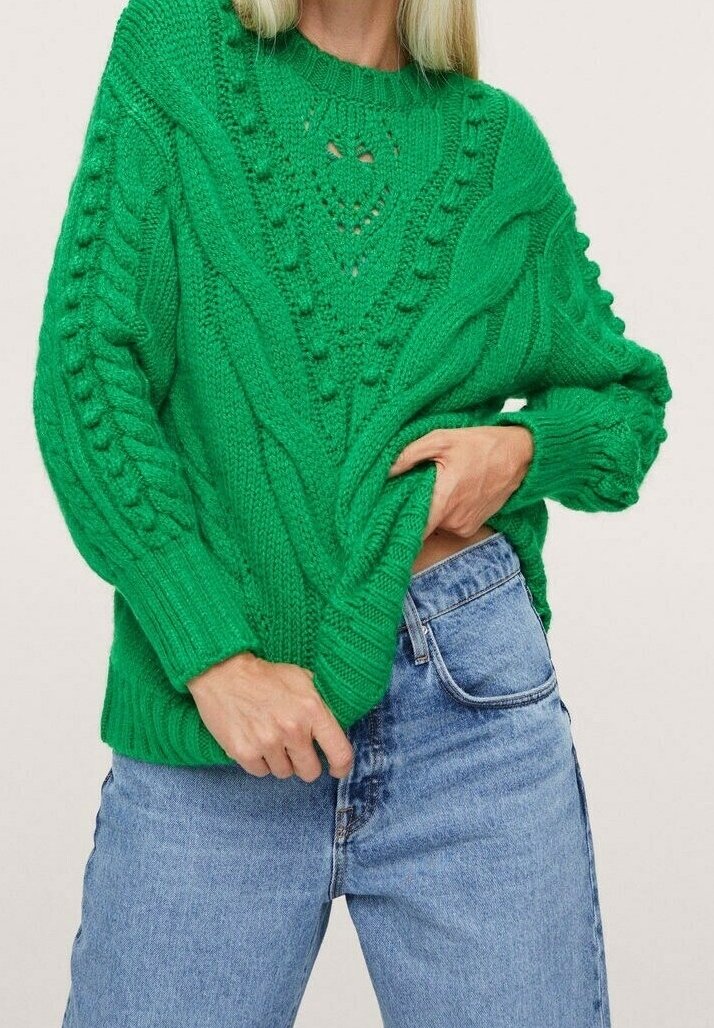 Groene gebreide trui met een getextureerd kabelpatroon, ronde halslijn en een ontspannen pasvorm, gedragen met lichtblauwe jeans.